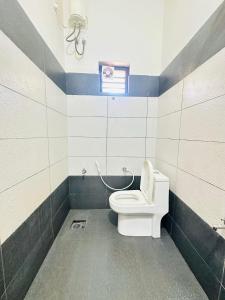 un bagno con wc e finestra di Grand Glorious Resort a Padinjarathara Altre 27 foto