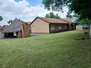een huis met een rieten dak en een grasveld bij Shivon Vaal Guest House in Vanderbijlpark