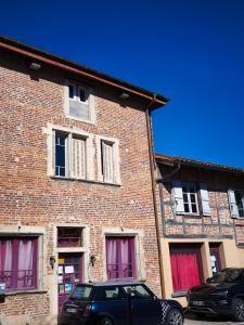 une voiture noire garée devant un bâtiment en briques dans l'établissement L'élégante, à Saint-Trivier-de-Courtes