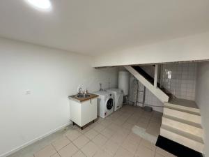 une buanderie avec une machine à laver et un escalier dans l'établissement L'élégante, à Saint-Trivier-de-Courtes