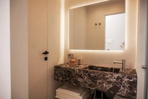une salle de bains avec un lavabo et un miroir dans l'établissement Iodis Relais, à Naples