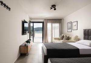 una camera da letto con un letto, un divano e una finestra di The Black Pearl Villas a Kalamítsi