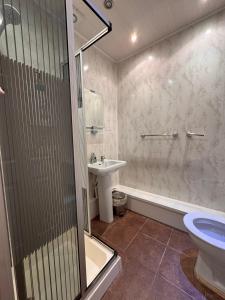 een badkamer met douche, wastafel en toilet bij No 34 Vance Road in Blackpool