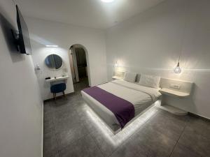 een witte slaapkamer met een bed en een bureau bij Markakis Studios Fira Town in Fira