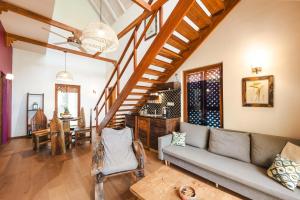 a living room with a couch and a staircase at Clove Island Villas & Spa in Makunduchi