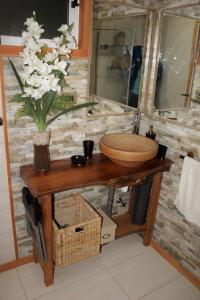 a bathroom with a sink and a vase of flowers on a table at Casa Loft Küme Felen in Pucón