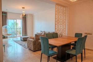 a dining room with a table and chairs and a couch at Marina Agadir Grand Luxury 3 Bedroom Sea view Apartment-familial in Agadir