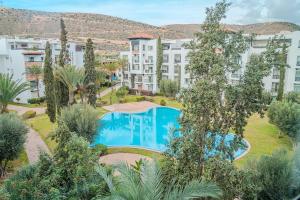 an apartment complex with a swimming pool and trees at Marina Agadir Grand Luxury 3 Bedroom Sea view Apartment-familial in Agadir