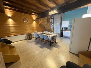 a dining room with a table and chairs and a kitchen at L Experience Bressane 2 in Saint-Trivier-de-Courtes