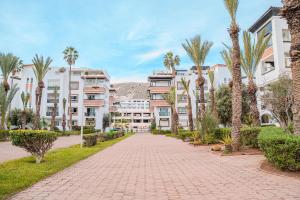 a brick walkway with palm trees and buildings at Marina Agadir Grand Luxury 3 Bedroom Sea view Apartment-familial in Agadir