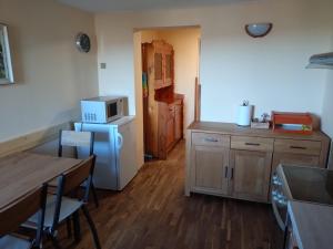 a kitchen with a table and a refrigerator and a table and chairs at Figura in Zdíkov +10 photos