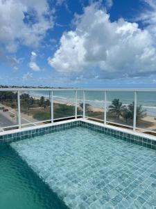 een zwembad met uitzicht op de oceaan bij Flat 201 Paradise in João Pessoa
