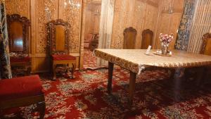 a room with a table with flowers on it at Heritage Houseboat - Almost Heaven in Srinagar