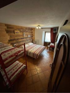 a room with two beds and a chair in it at Affittacamere L'Abri in Etroubles