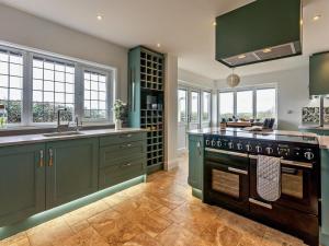 a kitchen with green cabinets and a stove at 3 Bed in Chale oc-94165 in Chale +28 photos
