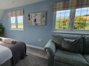 a bedroom with a couch and a bed and windows at 3 Bed in Chale oc-94165 in Chale