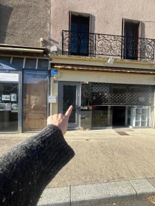 a person pointing at a building with their index finger at Le Secret' - Balnéo - Romantique Room in Pélussin