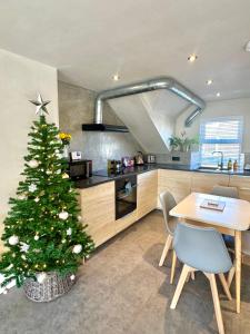 ein Weihnachtsbaum in einer Küche mit einem Tisch in der Unterkunft Palms 2 - Central, 5 mins walk to beach + parking! in Newquay