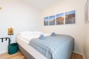 1 dormitorio blanco con 1 cama con manta azul en The Ísafjörður Inn by Ourhotels, en Ísafjörður 11 fotos más