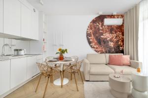 a kitchen and living room with a table and a couch at Premium & Elegance Apartments with Pool by Noclegi Renters in Sianozety