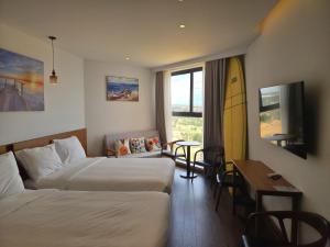 a hotel room with two beds and a table at Apec Mandala Wyndham ChamBay Mui Ne - LT in Mui Ne
