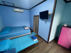 een kamer met 2 bedden en een tv. bij Sea Side Villa in Ban Pak Khlong Cha-am +30 foto's