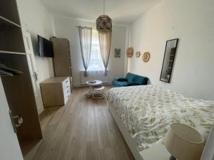 een slaapkamer met een bed en een blauwe stoel bij Le Jardin de Phanie, le calme de la campagne en ville in Metz