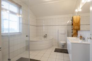 een badkamer met een bad, een toilet en een wastafel bij Appartementen Ossegang in Uithuizen +4 foto's