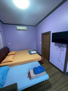 een kleine kamer met een bed en een flatscreen-tv bij Sea Side Villa in Ban Pak Khlong Cha-am