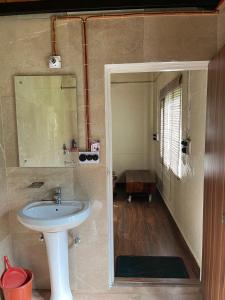 un bagno con lavandino e specchio di Nadi Kinare a Bhimtal