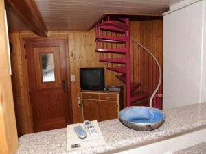 a kitchen with a red spiral staircase in a room at wooden chalet in Betten near the Aletsch Arena in Betten