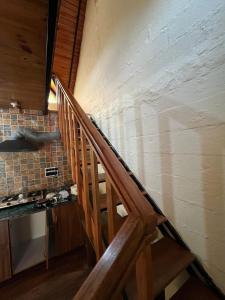 una scala in legno in una cucina con una parete di Nadi Kinare a Bhimtal Altre 7 foto