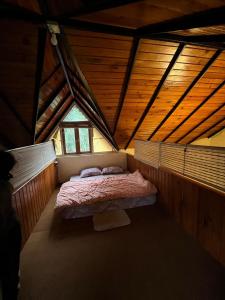 una piccola camera da letto con un letto in mansarda di Nadi Kinare a Bhimtal