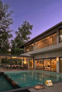 an exterior view of a house with a swimming pool at SaffronStays La Mia Casa in Jāmb