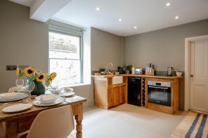 a kitchen with a wooden table and a stove at BATH Luxury Georgian Flat in Bath