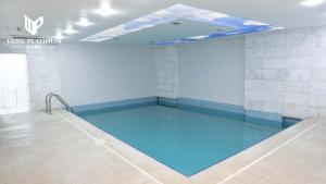 a large swimming pool in a room with blue water at Erbil Platinum Hotel in Erbil