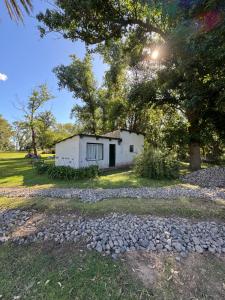 a small white building in the middle of a field at Casa del monte in Carmen de Areco