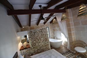 费雷列斯La Casa Menorca的浴室配有石制壁炉和浴缸。 更多54张照片