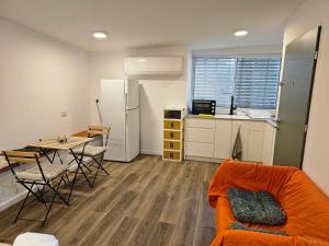 a living room with a couch and a table and a kitchen at יחידת סוקי in Zikhron Ya‘aqov