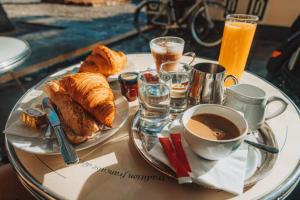 a table with a plate of pastries and a cup of coffee at Le Predhu Villa in Pondicherry