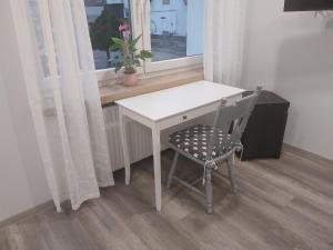 a desk and a chair in a room with a window at Flora Comfort Inn in Oberhausen