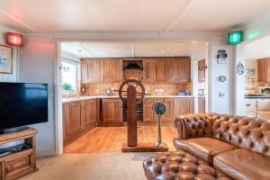 een woonkamer met een bank en een televisie bij Boathouse Bliss in Heacham