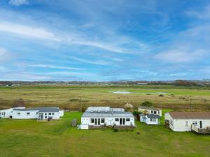 een groep witte huizen in een veld bij Boathouse Bliss in Heacham