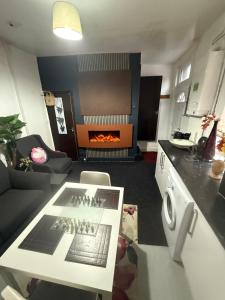 ein Wohnzimmer mit Tisch und ein Wohnzimmer mit Kamin in der Unterkunft Premiership Lodge in Beeston Hill