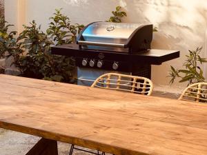 a grill sitting on top of a table next to a wooden table at Villa Depiros Corfu in Lefkimmi +57 photos