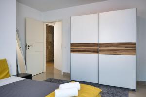 - une chambre avec un lit et une grande armoire blanche dans l'établissement Modern Station Apartment Mhlin, à Möhlin