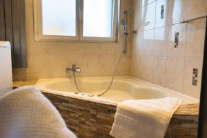 La salle de bains est pourvue d'une baignoire et d'une fenêtre. dans l'établissement Modern Station Apartment Mhlin, à Möhlin 16 autres photos
