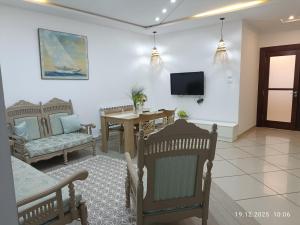a living room with a table and chairs and a tv at Résidence Debbabi in Monastir