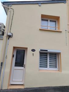 een wit huis met twee ramen en een deur bij Cajem in Étretat
