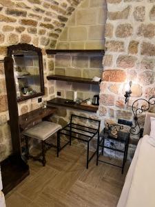 una camera con parete in pietra, panca e specchio di Arami Han Konağı a Mardin